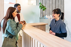 Couple talking to dental receptionist