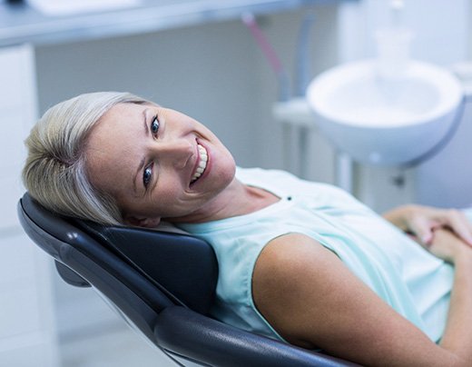 Female dental patient leaning back and smiling