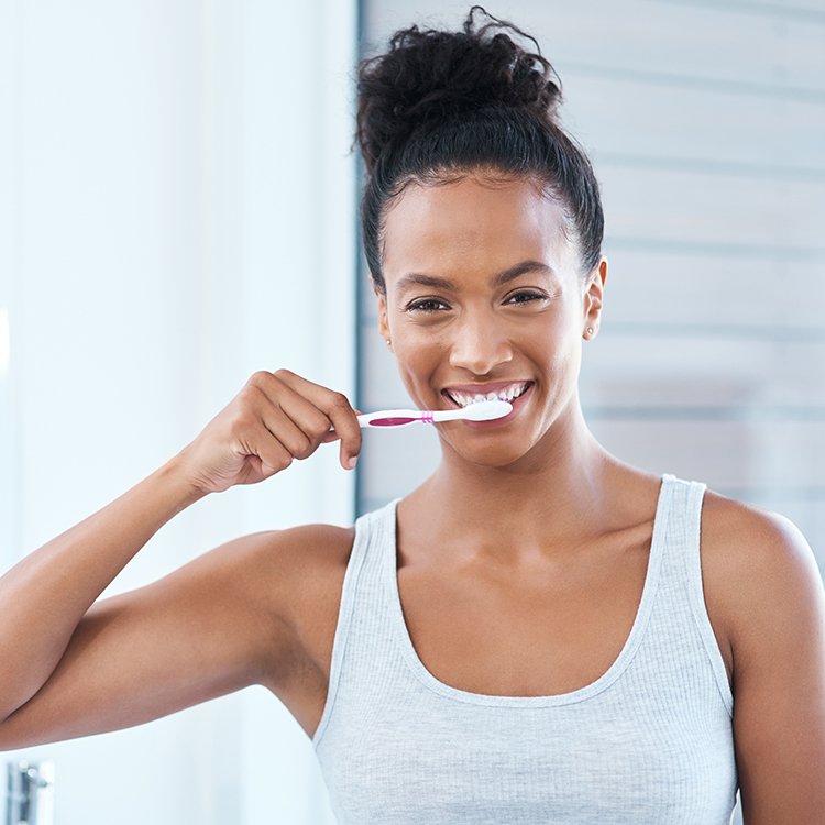 Woman brushing her teeth at home