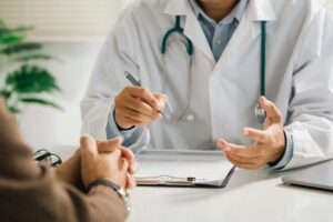 Doctor and patient sitting at desk, discussing health checkup